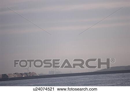 Stock Image - Tokyo Bay with wind turbines in the background. Tokyo Bay, Tokyo Prefecture, Japan. Fotosearch