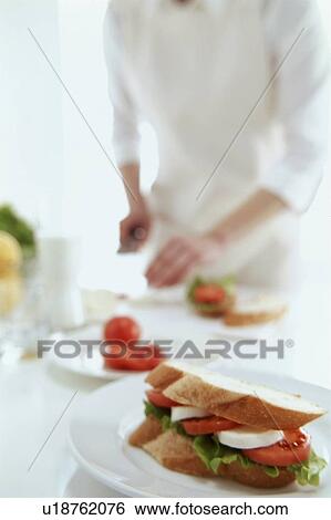 Stock Photograph - Tomato and mozzarella sandwich with chef in background. Fotosearch