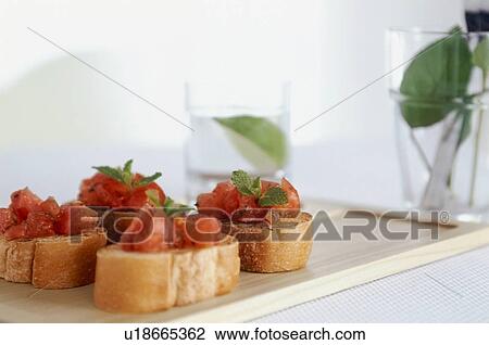 Stock Image - Tomato bruschetta with mint leaves. Fotosearch