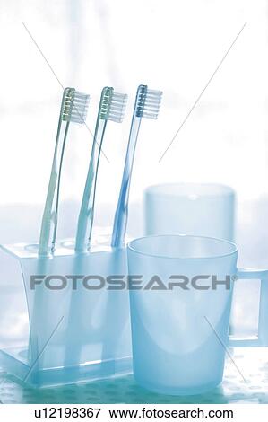 Stock Photo - Toothbrushes in holder and rinsing cup. Fotosearch