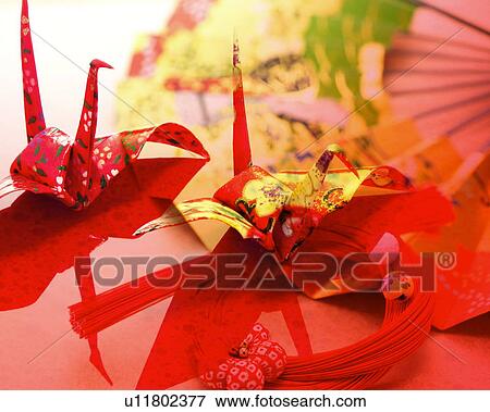 Stock Photo - Two Origami birds and folding fan, computer graphic, red background. Fotosearch