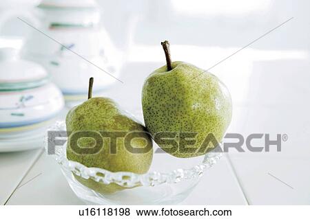 Stock Photo - Two pears in glass bowl, close up. Fotosearch