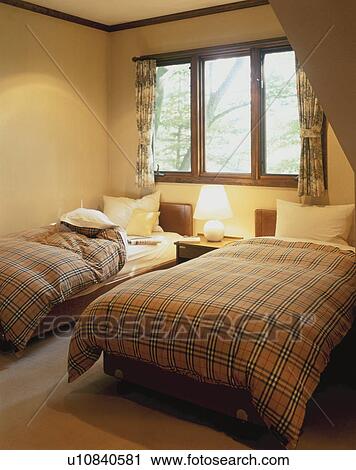 Stock Image - Two single beds in room with window. Fotosearch