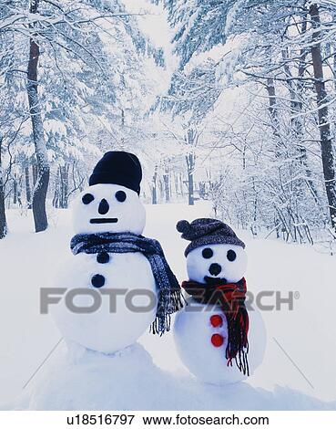 Two snowmen in a snowy forest View Large Photo Image Stock Photo - Two snowmen in a snowy forest. Fotosearch
