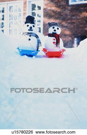 Two snowmen take to their toboggans View Large Photo Image Stock Photograph - Two snowmen take to their toboggans. Fotosearch