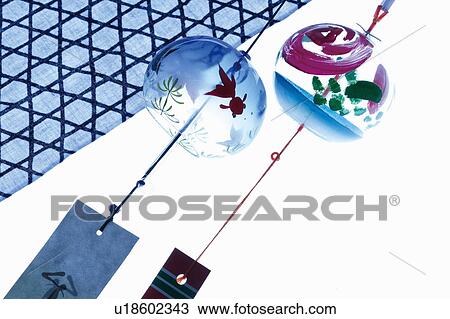 Stock Image - Two wind chimes, white background. Fotosearch