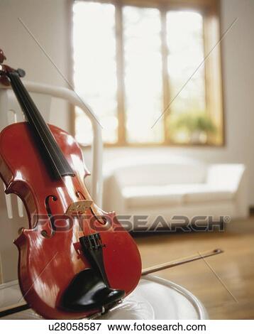 Violin on chair in bright living room View Large Photo Image Stock Photo - Violin on chair in bright living room. Fotosearch
