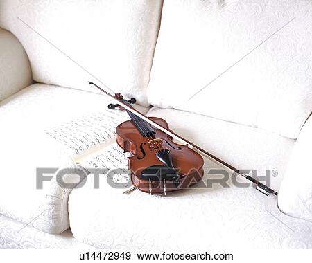 Violin on white sofa View Large Photo Image Stock Photo - Violin on white sofa. Fotosearch