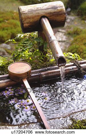 Stock Photograph - Water and bamboo ladle. Fotosearch