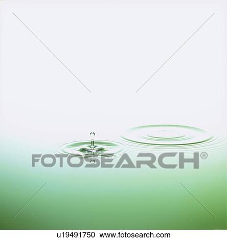 Stock Image - Water drop making ripple, copy space. Fotosearch