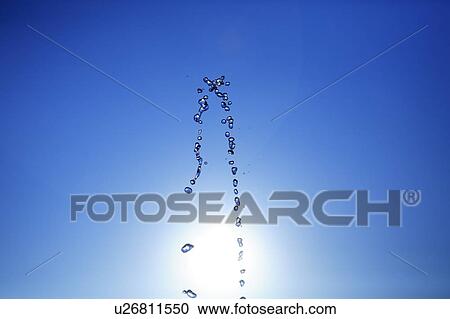 Stock Image - Water drops against blue sky, blue background. Fotosearch