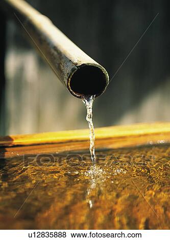 Stock Photo - Water flowing from a bamboo pipe, Kyoto, Japan. Fotosearch