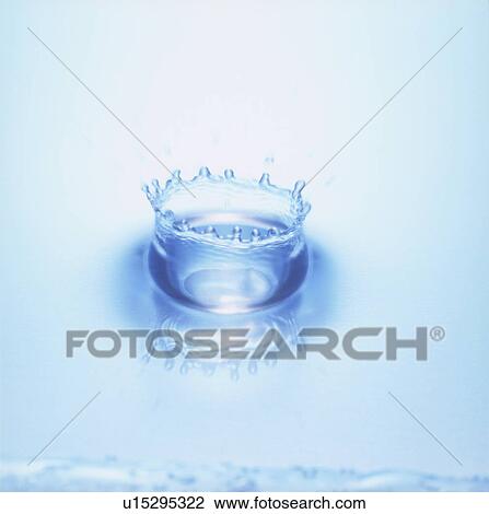 Stock Image - Water splashing, close up, blue background. Fotosearch