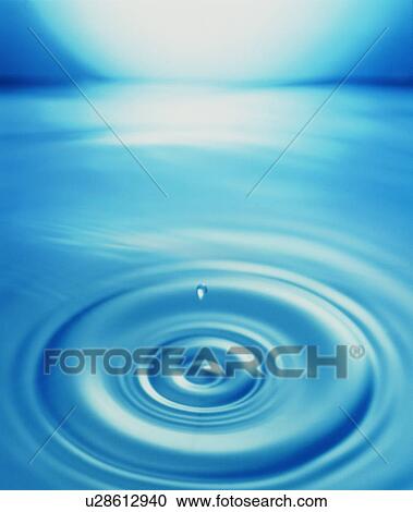 Stock Image - Waterdrop and ripples on water surface. Fotosearch