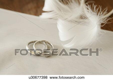 Stock Photo - Wedding rings and feathers. Fotosearch