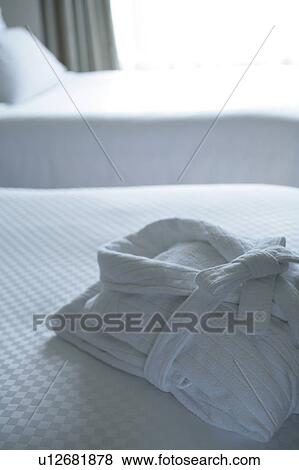 Stock Photo - White bathrobe on bed. Fotosearch