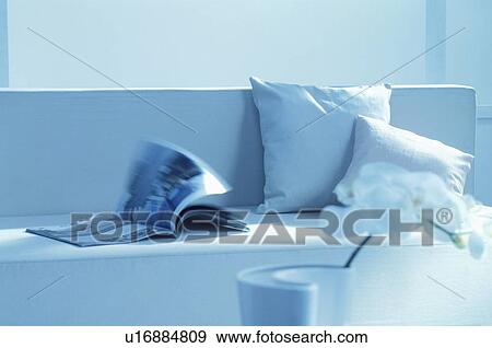 Stock Photo - White sofa with magazine and cushions. Fotosearch