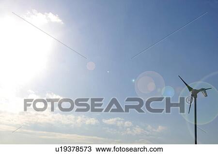 Stock Image - Wind turbine against blue sky with clouds. Fotosearch