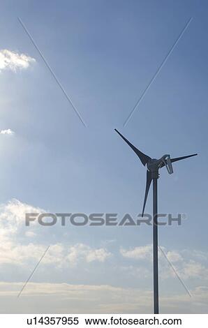 Stock Photography - Wind turbine against blue sky with clouds. Fotosearch