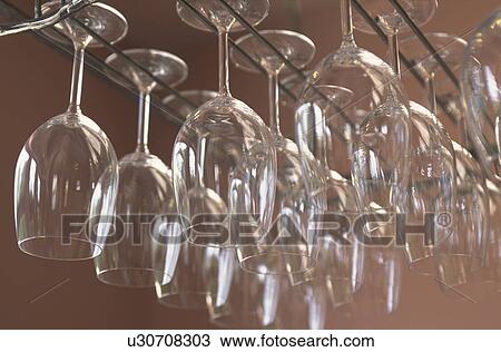 Stock Image - Wineglasses hanging from a rack. Fotosearch