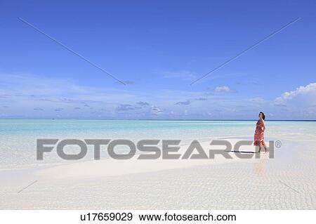 Stock Photo - Woman at white sand beach, Maldive Islands. Fotosearch