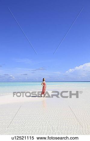 Stock Photography - Woman at white sand beach, Maldive Islands. Fotosearch