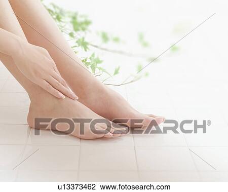 Woman giving herself a foot massage View Large Photo Image Stock Image - Woman giving herself a foot massage. Fotosearch