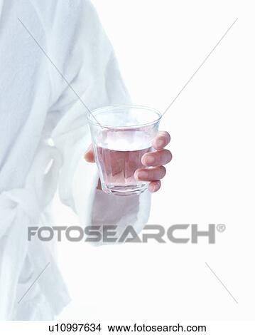 Picture - Woman in bath robe holding glass of water. Fotosearch
