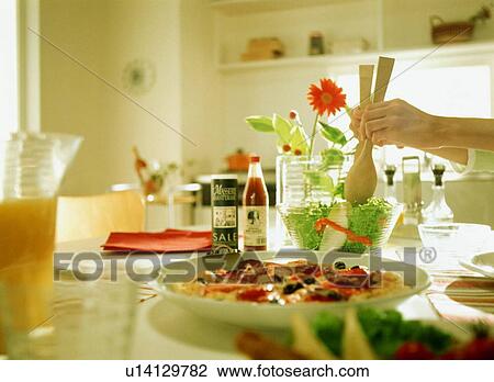 Stock Image - Woman serving salad. Fotosearch