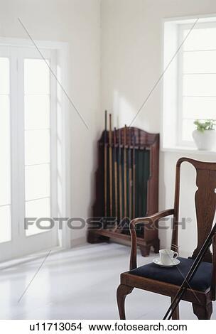 Wooden chair and cue of billiards in white room View Large Photo Image Picture - Wooden chair and cue of billiards in white room. Fotosearch