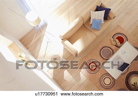 Stock Image - Wooden floored living room with beige sofa. Fotosearch