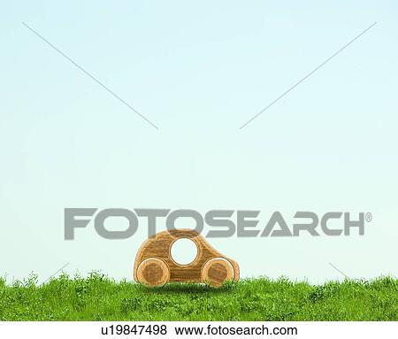 Stock Photo - Wooden Toy Car on Green Field. Fotosearch