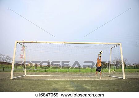 Stock Photo - Young boy goalkeeping on field. Futako-tamagawa, Setagaya-ku, Tokyo Prefecture, Japan. Fotosearch