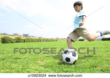 Young boy kicking soccer ball on field. Futako-tamagawa, Setagaya-ku, Tokyo Prefecture, Japan View Large Photo Image Picture - Young boy kicking soccer ball on field. Futako-tamagawa, Setagaya-ku, Tokyo Prefecture, Japan. Fotosearch