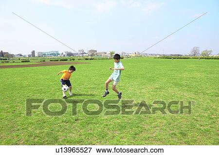 Young boys playing soccer on field. Futako-tamagawa, Setagaya-ku, Tokyo Prefecture, Japan View Large Photo Image Stock Photo - Young boys playing soccer on field. Futako-tamagawa, Setagaya-ku, Tokyo Prefecture, Japan. Fotosearch