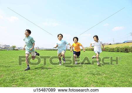 Stock Photo - Young boys running on field. Futako-tamagawa, Setagaya-ku, Tokyo Prefecture, Japan. Fotosearch
