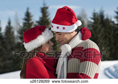 Couple in Christmas outfit embracing View Large Photo Image Stock Photo - Couple in Christmas outfit embracing. Fotosearch