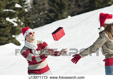 Couple in Christmas outfit, throwing a present View Large Photo Image Stock Image - Couple in Christmas outfit, throwing a present. Fotosearch