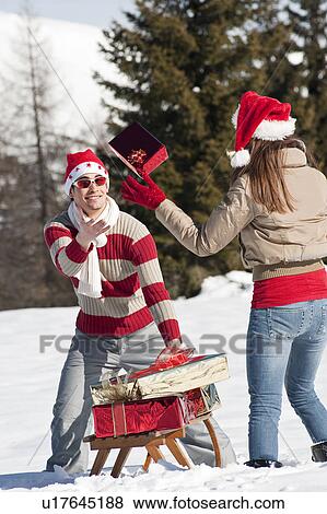 Couple in Christmas outfit, throwing a present View Large Photo Image Stock Photo - Couple in Christmas outfit, throwing a present. Fotosearch