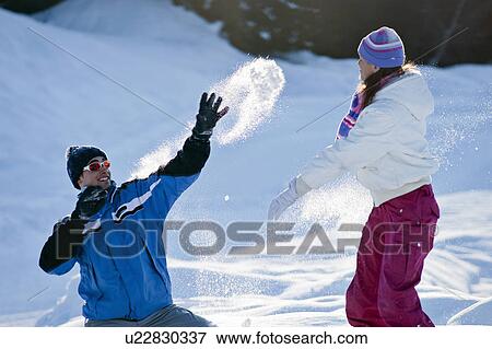 Stock Photo - Couple play fighting in snow. Fotosearch