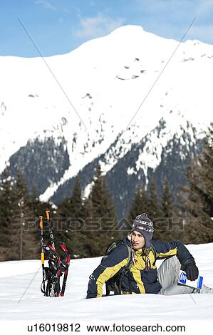 Young man sitting in snow with hiking gear View Large Photo Image Stock Image - Young man sitting in snow with hiking gear. Fotosearch