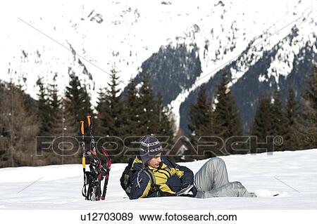 Young man sitting in snow with hiking gear View Large Photo Image Stock Photo - Young man sitting in snow with hiking gear. Fotosearch