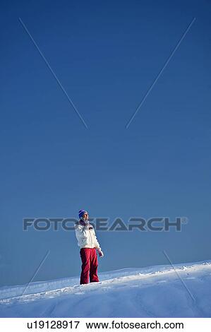 Stock Photo - Young woman in snow talking on mobile. Fotosearch