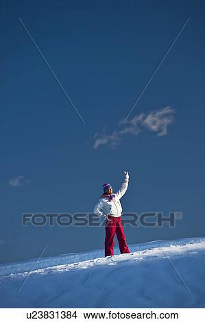 Picture - Young woman in snow waving. Fotosearch
