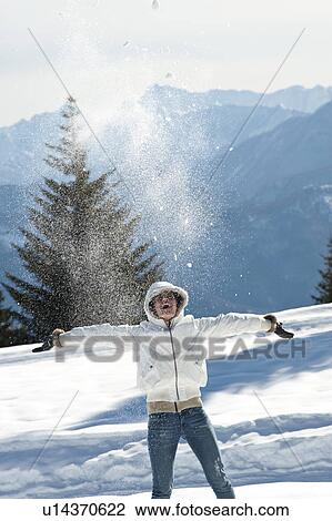 Young woman in winter scene with snow spray, arms outstretched View Large Photo Image Stock Image - Young woman in winter scene with snow spray, arms outstretched. Fotosearch