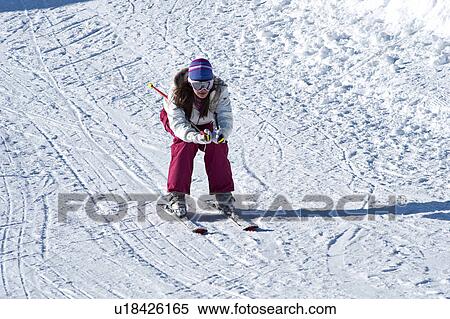 Stock Photography - Young woman skiing downhill. Fotosearch