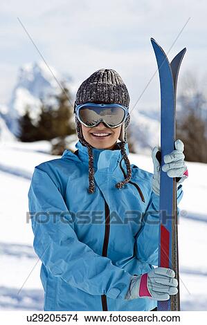Picture - Young woman with skis and ski shades. Fotosearch