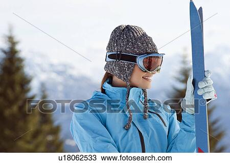 Stock Image - Young woman with skis and ski shades. Fotosearch