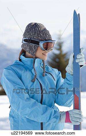 Stock Photo - Young woman with skis and ski shades. Fotosearch