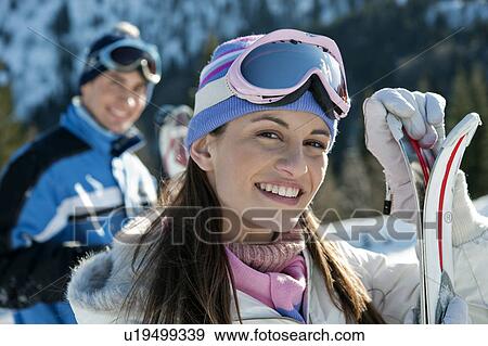Stock Photo - Young woman with skis. Fotosearch
